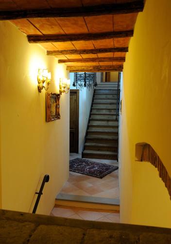 a hallway with a staircase with yellow walls and a yellow wall at Tenuta dei Cavalieri in Molino del Piano
