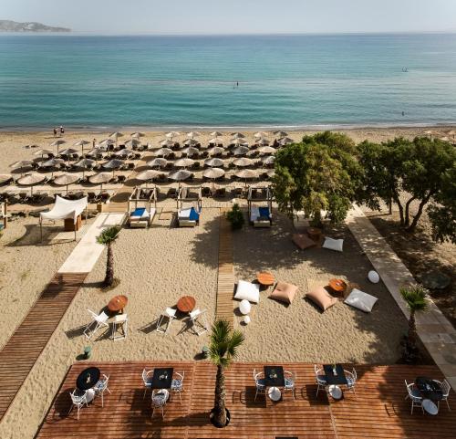 an overhead view of a beach with chairs and umbrellas at Enorme Teatro Beach in Amoudara Herakliou