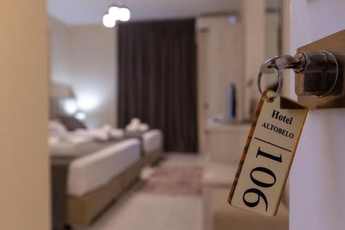 a hotel room with a sign hanging from a door at Altobelo Hotel in Vlorë