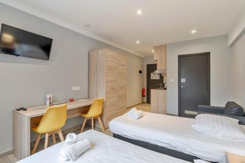 a hotel room with two beds and a desk at Budget Flats Leuven in Leuven