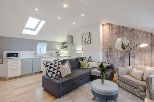a living room with a couch and a kitchen at Kings Cross Two Bedroom Penthouse in London