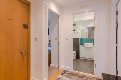 a bathroom with a toilet and a sink and a door at Kings Cross Two Bedroom Penthouse in London