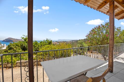 a white table on a balcony with a view of the ocean at Delta Sea View House in Plataniás