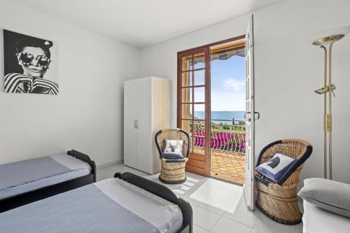 - une chambre avec un lit, des chaises et un balcon dans l'établissement La Belle Provence, à Roquebrune-sur Argens