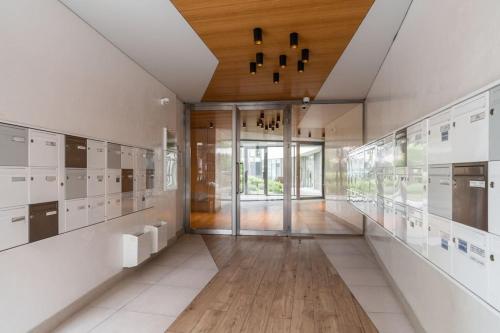 un grand couloir avec des armoires blanches et un plafond en bois dans l'établissement Appartement incroyable en région parisienne, à Boulogne-Billancourt