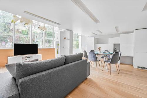 un salon avec un canapé gris et une table dans l'établissement Le 21 - Appart 4P 2BDR - Proche Paris - Wifi, à Saint-Maur-des-Fossés