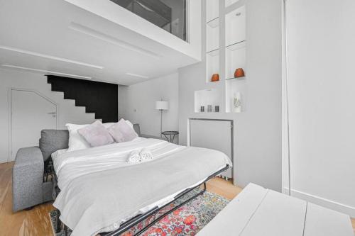 - une chambre blanche avec un lit et un escalier dans l'établissement Le 21 - Appart 4P 2BDR - Proche Paris - Wifi, à Saint-Maur-des-Fossés