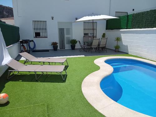 a backyard with a swimming pool and grass at Casa Cristy in Montejaque