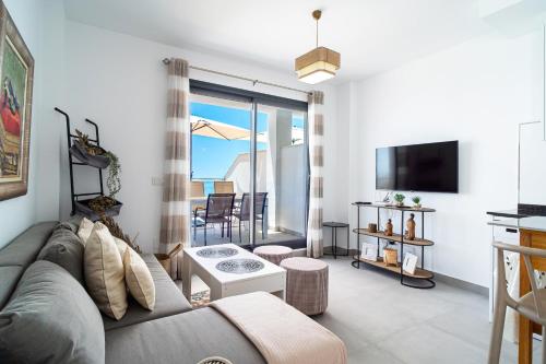 Una sala de estar con un sofá y un televisor. en Terrazas de Ladera A2 Luxury by Casasol, en Nerja
