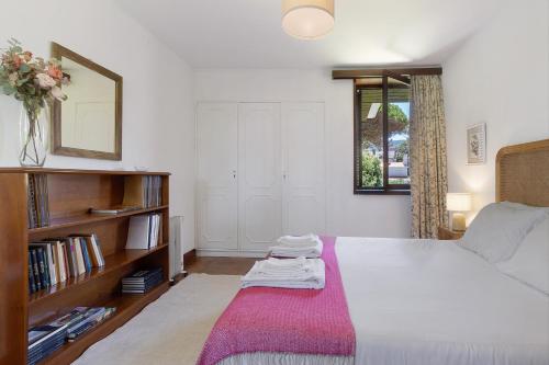 a bedroom with a bed and a shelf with books at Casa de Santo António Moledo in Moledo