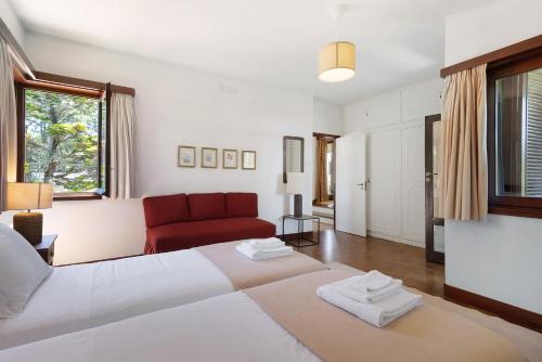 a bedroom with a large bed and a red couch at Casa de Santo António Moledo in Moledo
