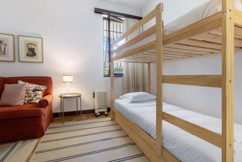 a bedroom with two bunk beds and a couch at Casa de Santo António Moledo in Moledo