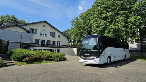 a black and white bus parked in front of a house at Auberge de Jeunesse de Mulhouse in Mulhouse