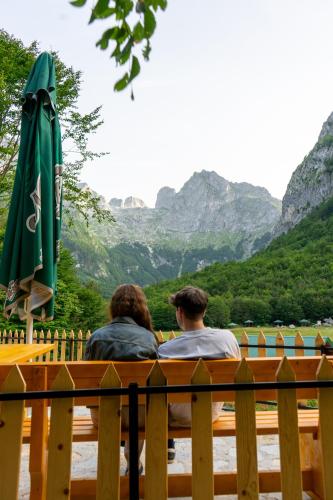 two people sitting on a bench with an umbrella at WildBeauty Grebaje in Vusanje