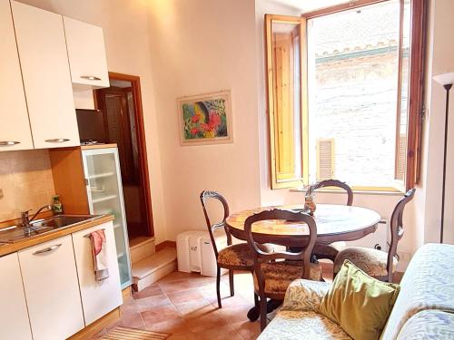 a kitchen with a table and a dining room at Flat Ghino di Tacco historical centre Radicofani in Radicofani