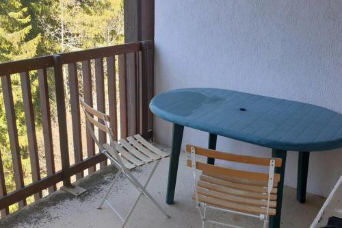 a blue table and a chair on a balcony at Duplex lumineux et spacieux en plein centre bourg in Saint-Pierre-de-Chartreuse
