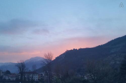 a sunset over a mountain with trees and houses at Spacieux studio Pré de chartreuse 2 in Saint-Pierre-de-Chartreuse