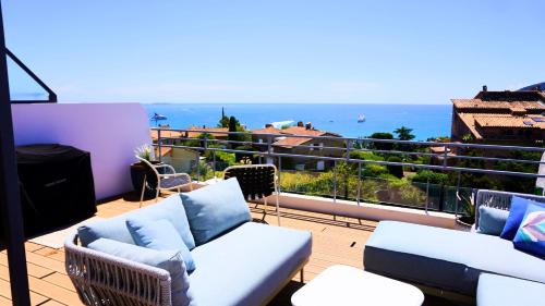 a balcony with couches and a view of the ocean at Villa avec Rooftop, Jacuzzi & vue mer by Palmazur in Mandelieu-la-Napoule