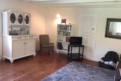 a living room with a white cabinet and a television at Charmante maison familiale in Saint-Pierre-de-Chartreuse