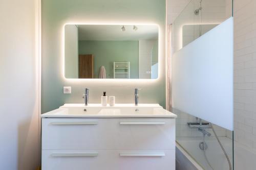 une salle de bain avec un lavabo blanc et un miroir dans l'établissement Villa avec piscine à Marseille, à Marseille