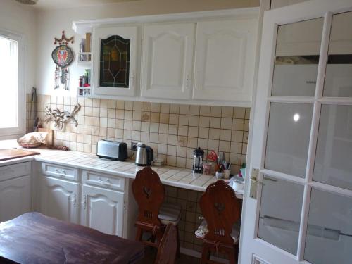 a kitchen with white cabinets and a table and chairs at Spacious Room for Rent in Le Pecq in Le Pecq