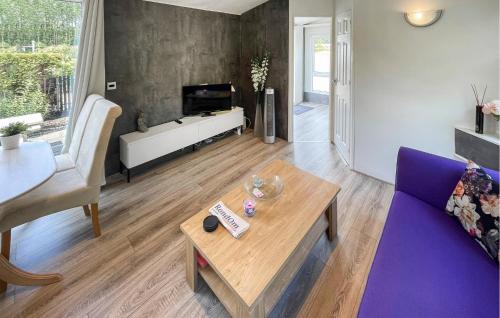 a living room with a purple couch and a table at Stunning Stacaravan In Tzummarum in Tzummarum