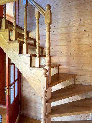 a wooden staircase in a log home with a wooden wall at Садиба Кичера in Petrashani