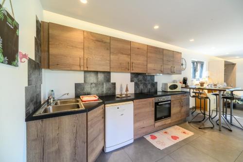 a kitchen with wooden cabinets and a sink at Gite Au Petit Mittlach in Mittlach