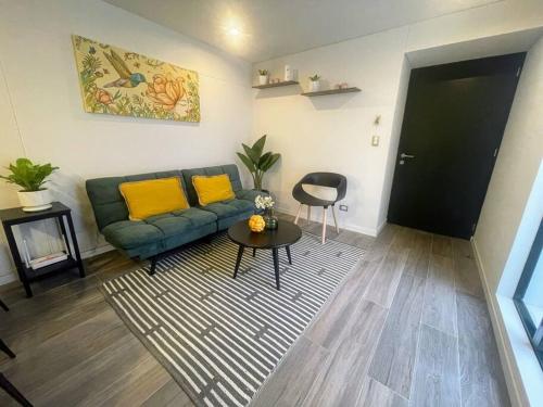 a living room with a green couch and yellow pillows at Cómodo y silencioso Apartamento 1BR en Barranco in Lima