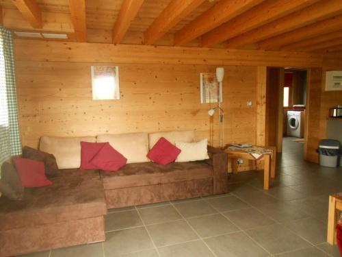 - un salon avec un canapé marron et des oreillers rouges dans l'établissement Gîte du Rotenberg, à Bergheim