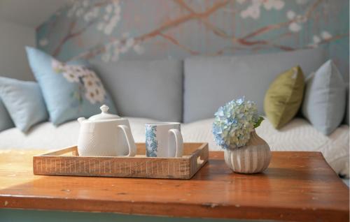 une table basse en bois avec une théière et un vase de fleurs dans l'établissement 1 Bedroom Cozy Apartment In Saint-Renan, à Saint-Renan