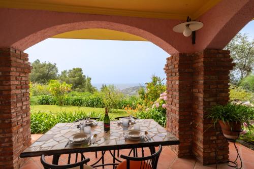 a patio with a table with a bottle of wine at Into the Green! Imperia Appt with Parking & Pool in Barcheo