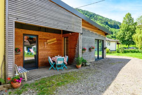 a patio with a table and chairs outside of a house at Gite Au Petit Mittlach in Mittlach