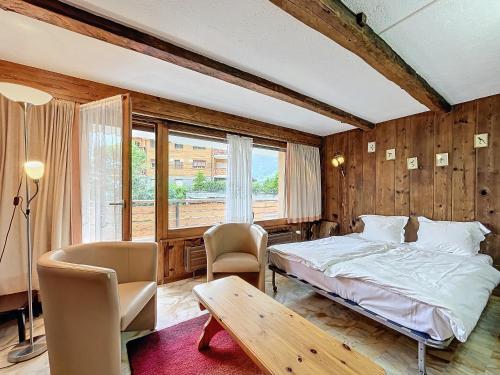 a bedroom with a bed and a table and chairs at Cimerose 1 in Verbier