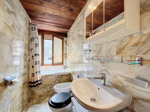 a bathroom with a sink and a toilet at Cimerose 1 in Verbier