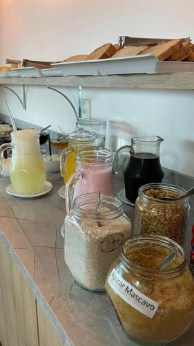a counter with many different jars of food on it at Hotel Ametista in Ametista do Sul