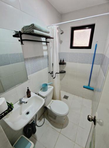 a bathroom with a white toilet and a sink at Bahay ni Asik - Homestay near SM City in Davao City