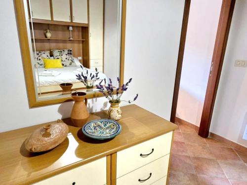 a room with a dresser with a mirror and a bed at Flat Ghino di Tacco historical centre Radicofani in Radicofani