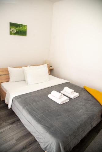 a bedroom with a bed with two towels on it at Apartmani Maslačak in Vrdnik