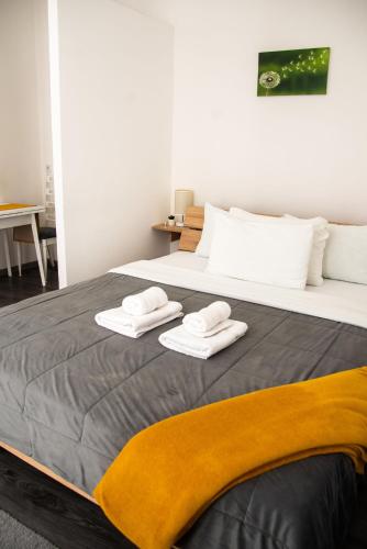 a bedroom with a large bed with towels on it at Apartmani Maslačak in Vrdnik