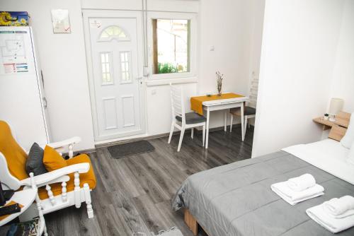 a bedroom with a bed and a desk and a table at Apartmani Maslačak in Vrdnik