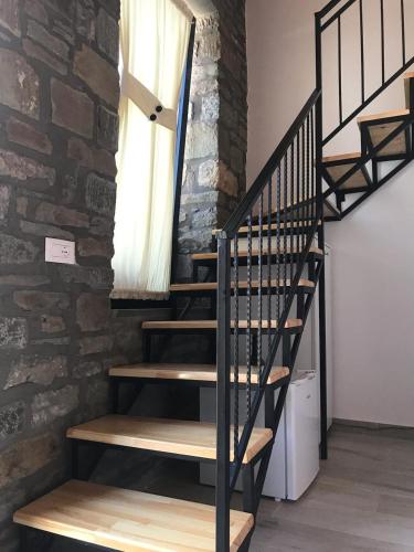 a spiral staircase in a room with a brick wall at Gogo Moustache Guest House in Përmet