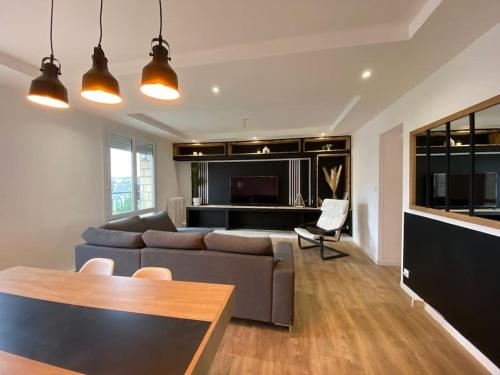 un salon avec un canapé et une table dans l'établissement Appartement cosy - Le Verdun, à Caen