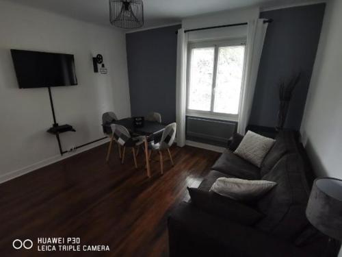 un salon avec un canapé et une table dans l'établissement IDEAL, appartement moderne, confortable et cosy, à Gérardmer
