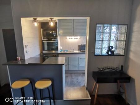 une cuisine avec deux tabourets de bar et un comptoir dans l'établissement IDEAL, appartement moderne, confortable et cosy, à Gérardmer