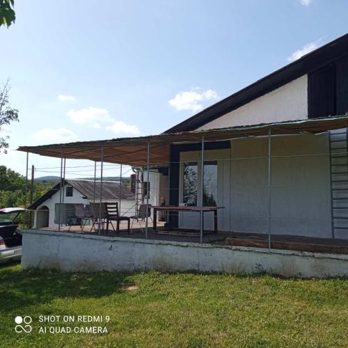 a screened in porch of a house with a table and chairs at Kuća za odmor Fruška gora in Prnjavor