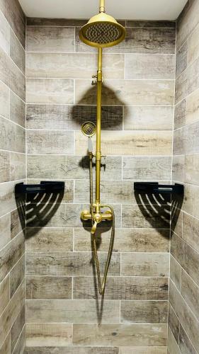 une douche avec une lumière jaune sur un mur dans l'établissement La Maison des Sortilèges, à Perpignan