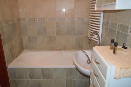 a bathroom with a bath tub and a sink at Levendula Vendégház in Mórahalom