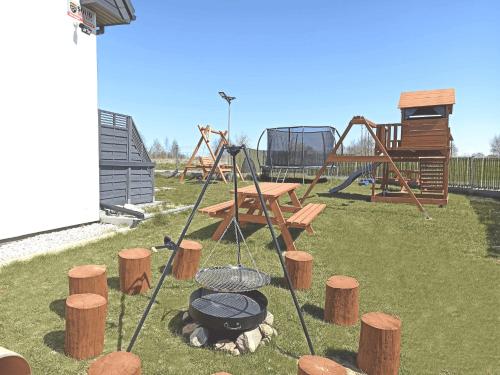 a park with a playground with a grill and a picnic table at MILAN Domki Mielno in Mielno
