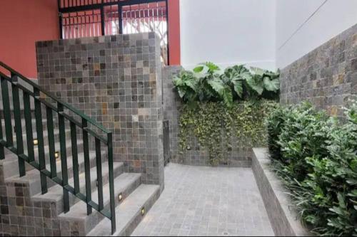 a hallway with stairs and plants in a building at Cómodo y silencioso Apartamento 1BR en Barranco in Lima